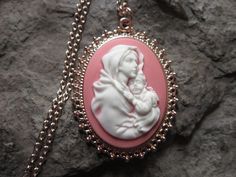 "Wonderful look for Easter and Christmas!! Beautiful Virgin Mary cradling baby Jesus cameo necklaces, choose purple, pink, blue or gray background. The cameos are gorgeous. I do have many other colors, finishes and styles, so please do browse, I can make any larger cameo in my shop into this pretty necklace, so browse and message me with a custom order The pretty setting is classically beautiful rose gold tone, which measures about 2 1/4\" long. The chain is a matching 24\" rose gold link chain Handmade Pink Necklace For Mother's Day, Vintage Pink Necklace For Mother's Day, Handmade Pink Jewelry For Christmas, Handmade Pink Jewelry For Holiday, Personalized Pink Jewelry For Christmas, Elegant Pink Christmas Jewelry, Pink Cameo Jewelry As A Gift, Pink Cameo Necklace For Gifts, Cameo Pendant Necklace