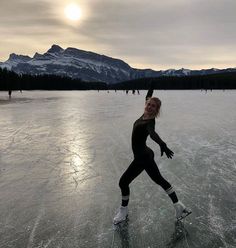 a woman skating on an ice covered lake