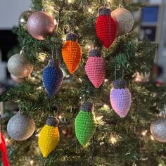 a crocheted christmas ornament hanging from the top of a decorated christmas tree