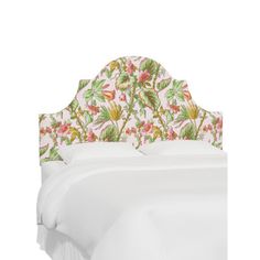 an upholstered headboard with flowers and leaves on the top, against a white background