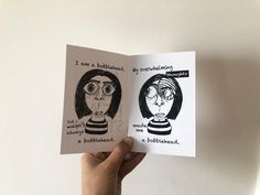 someone is holding up a book with two drawings on the front and back of it