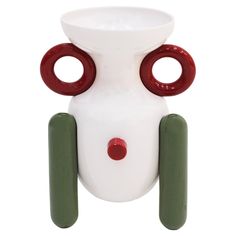 a white vase with two red and green circles on it's sides, sitting in front of a white background