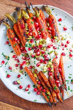 carrots with pomegranate and white sauce on a plate