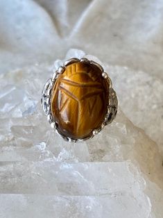 Art Deco Egyptian Revival Carved Tigers Eye Scarab Sterling Silver Vintage Ring ring size 6 Symbolic Carved Round Ring, Spiritual Carved Round Ring, Symbolic Carved Ring, Ceremonial Oval Cabochon Rings, Artisan Carved Rings, Oval Ceremonial Carved Jewelry, Symbolic Oval Gemstone Jewelry, Collectible Brown Gemstone Rings, Spiritual Oval Gemstone Engraved Ring