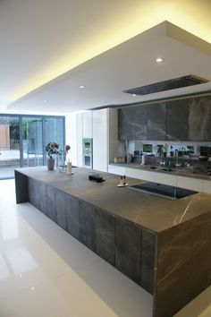 a modern kitchen with marble counter tops and stainless steel appliances, along with large sliding glass doors that lead to an outdoor patio