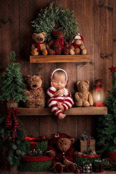 a baby sleeping on top of a shelf surrounded by christmas decorations