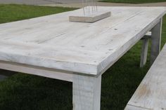 a wooden table and bench in the grass with candlesticks sticking out of it