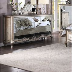 a bedroom scene with focus on the bed and mirror cabinet in the foreground, along with an area rug