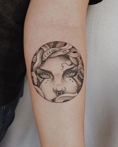 a woman's face in a circle tattoo on the arm