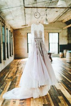 a wedding dress hanging in the middle of a room