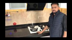 a man standing in front of a stove top oven with two burners on it