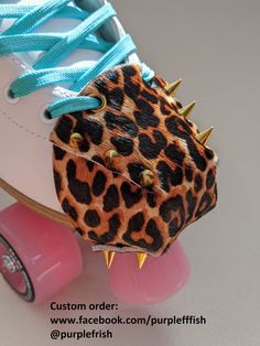 an animal print shoe with spikes attached to the heel and laces on it's sides