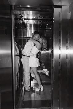 a man and woman kissing in an elevator