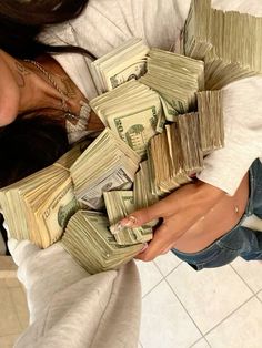 a woman holding stacks of money in her hands