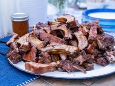 a plate full of cooked meat sitting on a table next to a jar of honey