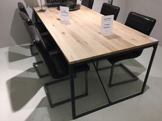 a wooden table with black chairs around it