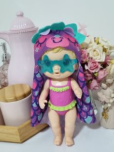 a doll with sunglasses and a purple outfit