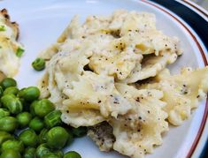 a white plate topped with pasta and peas