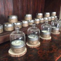 many jars with candles inside on a table