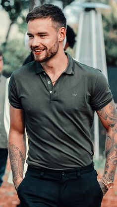 a man with tattoos on his arm walking