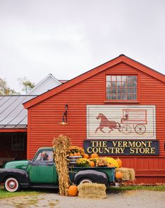 an old truck parked in front of a red building with a sign that says the vermont country store