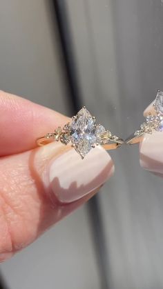 a woman's hand holding two diamond engagement rings