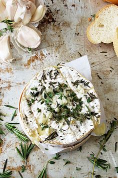 a bowl filled with food sitting on top of a table next to garlic and bread