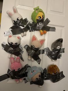 a bunch of stuffed animals are hanging on the front door with black ribbon around them