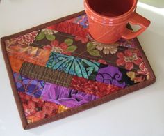 a colorful patchwork place mat with a coffee cup on it