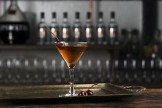 a glass filled with liquid sitting on top of a metal tray