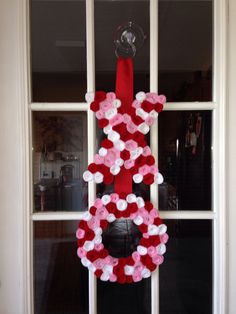 a wreath made out of hearts hangs on the front door to celebrate valentine's day