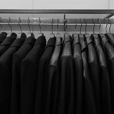 black and white photograph of clothes hanging on rail