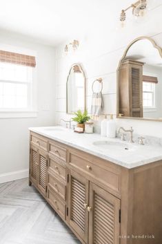 a bathroom with two sinks and mirrors in it