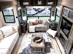 a living room filled with furniture and windows next to a fire place in a trailer