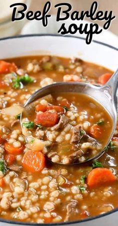 a spoon full of beef barley soup with carrots and parsley in the bowl