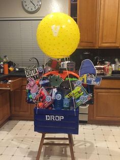 a blue crate filled with items sitting on top of a kitchen floor next to a clock