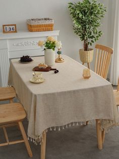 a dining room table with a potted plant next to it and other items on the table