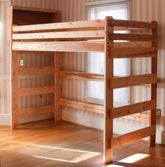 a wooden bunk bed sitting on top of a hard wood floor next to a window