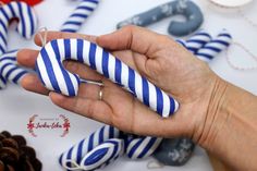 a hand holding a blue and white striped ring