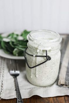 a jar filled with whipped cream sitting on top of a table next to a spoon