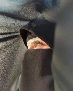 a woman with her eyes covered by a black cloth