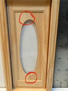 a wooden frame with an oval hole in the middle and two red circles around it