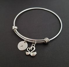 "Personalized Antique Silver Swan Bangle Bracelet! A sweet mother and baby swan charm on an expandable bangle bracelet makes the perfect gift for you or a new mom. The swan bracelet charm is made from zinc alloy and measures 15 mm by 14 mm. The bangle bracelet is high quality stainless steel and fits a wrist sized 6-8\". The swan bangle bracelet is personalized with a .5\" silver plated disc stamped with the initial of your choice. The charm and initial disc are connected to the bangle with stur Adjustable Personalized Dangle Bracelets, Adjustable Charm Bracelets For Anniversary, Adjustable Dangle Bracelets For Anniversary, Swan Bracelet, Swan Jewelry, Baby Swan, Bible Verse Bracelet, Mother Daughter Bracelets, Family Bracelets