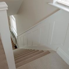 an empty staircase with carpeted steps leading up to the second floor and another room in the background