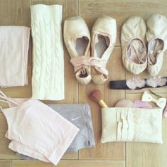 several pairs of ballet shoes and clothing laid out on the floor