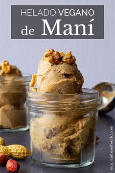 two jars filled with ice cream sitting on top of a table next to some nuts