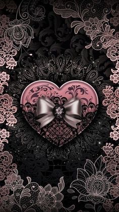 a pink heart with a bow on top of it in the middle of black and white lace