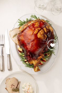 a turkey is sitting on a plate next to silverware and utensils, along with other food