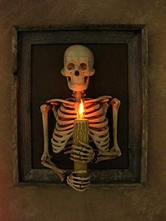 a skeleton holding a lit candle in its hand