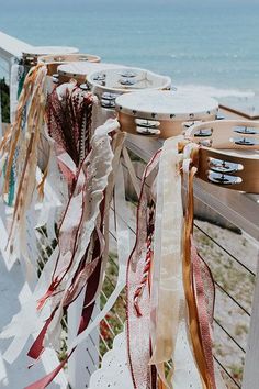 some ribbons are hanging on a fence by the beach